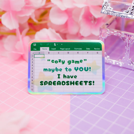 "Cozy game! Maybe to YOU! I have SPREADSHEETS!" holographic vinyl sticker